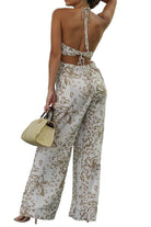 Woman in a floral outfit standing in front of a glass wall.